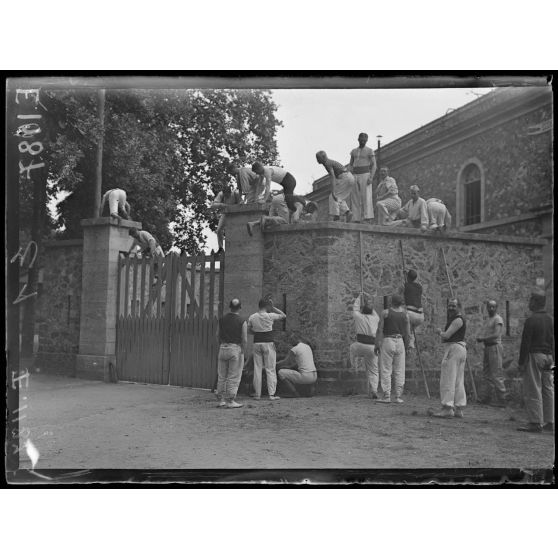 Joinville-le-Pont (Seine). Ecole normale militaire de gymnastique. L'escalade d'un mur. [légende d'origine]