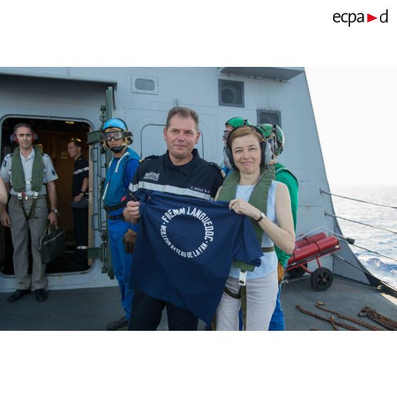 Le capitaine de vaisseau Guillaume Arnoux offre un cadeau à la ministre des Armées, lors de sa visite à bord de la frégate multimissions (FREMM) Languedoc.