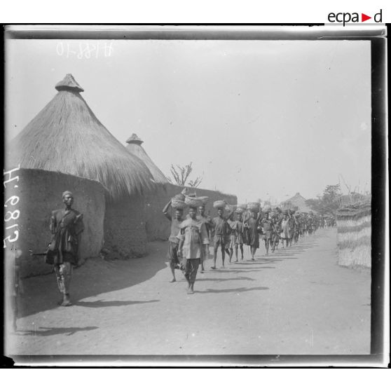 N'Gaoundéré village. Un convoi de ravitaillement dans les rues du village. [légende d'origine]