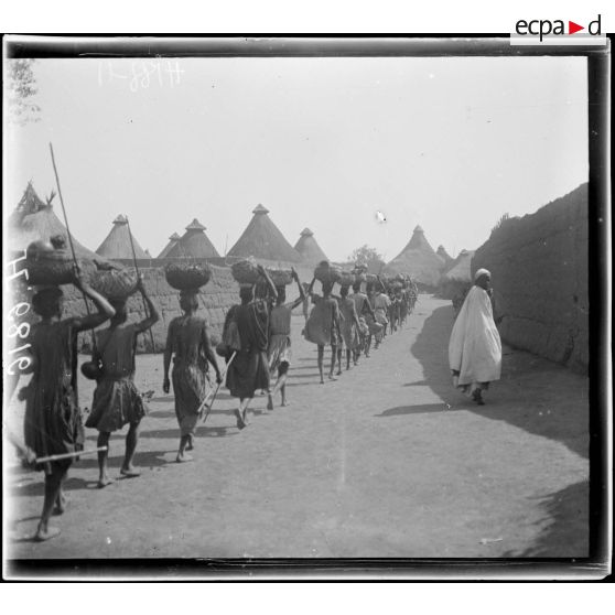 N'Gaoundéré village. Un convoi de ravitaillement dans les rues du village. [légende d'origine]