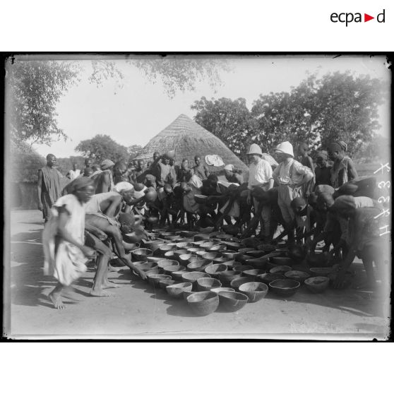 Piste de Garoua à Tschamba. Kalgé. Distribution de vivres aux porteurs. [légende d'origine]