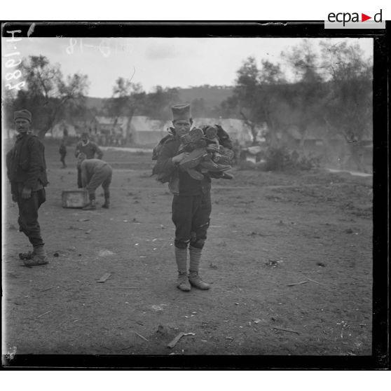 Govino. Camp de Serbes. Serbe portant un lot de chaussures neuves. [légende d'origine]