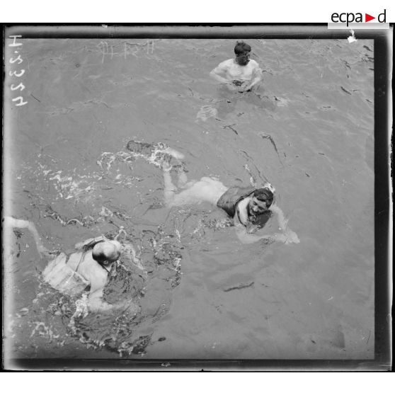 En mer. Exercice de natation (les hommes munis de ceinture de sauvetage). [légende d'origine]