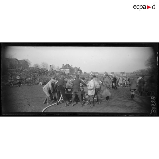 Compiègne. On arrose les débris en feu du zeppelin. [légende d’origine]