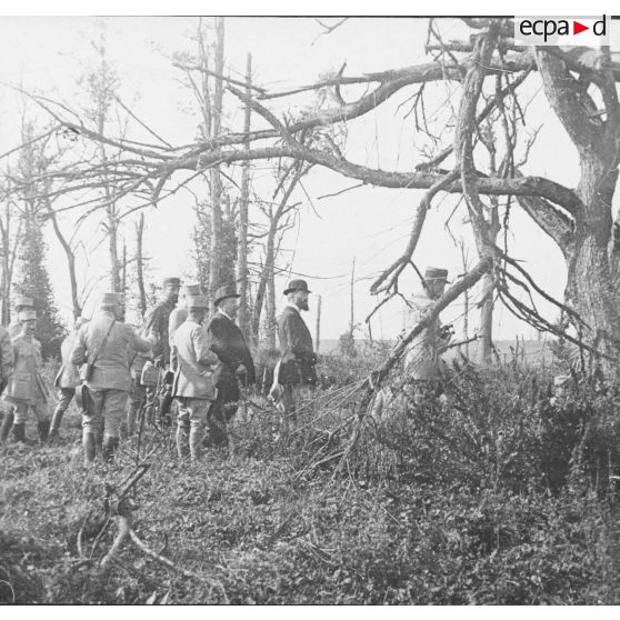 [Lors d'une journée d'expérimentations, Jules-Louis Breton et d'autres autorités civiles et militaires se font conduire par un officier supérieur sur un terrain boisé, s.d.]