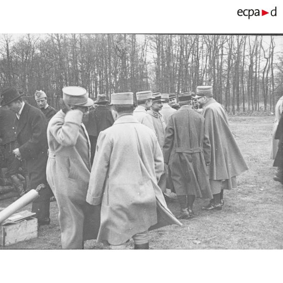 [Groupe d'officiers supérieurs réunis autour d'une table lors d'une présentation de projectiles de tranchée, s.d.]