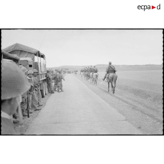 Vie quotidienne au 8e RIM. Vue du convoi militaire à l'arrêt. Sur la droite, la colonne des spahis passe le long de la route. [légende d'origine]