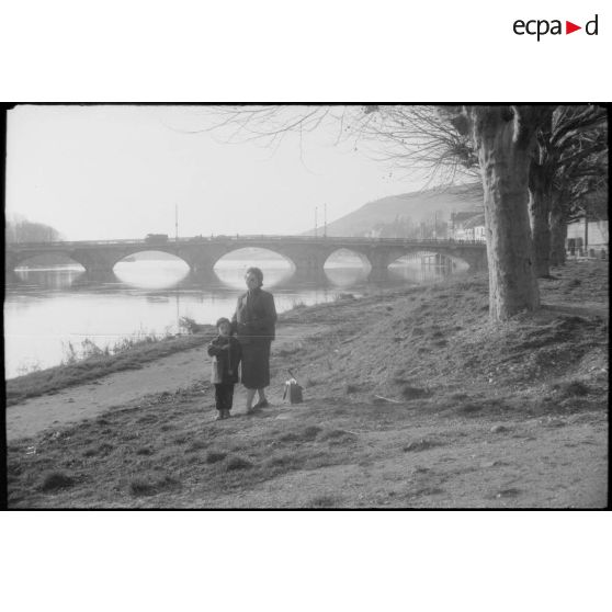 Portrait en bordure de canal. En arrière-plan, un pont. [légende d'origine]