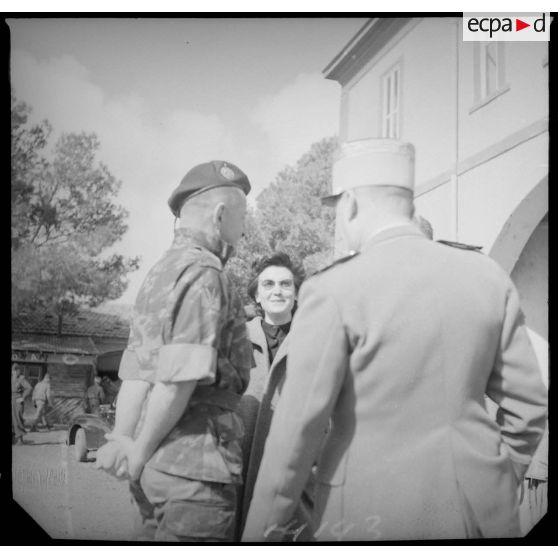 Le colonel Bigeard discute avec une femme et des officiers. [légende d'origine]