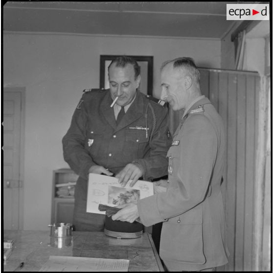 [Camp des chasseurs dans le département de Saïda. Le colonel Maire commandant du 1/8e RIM (à droite) et son adjoint, le commandant Rouquette, regardent une plaquette sur Saïda réalisée par Arthur Smet.]