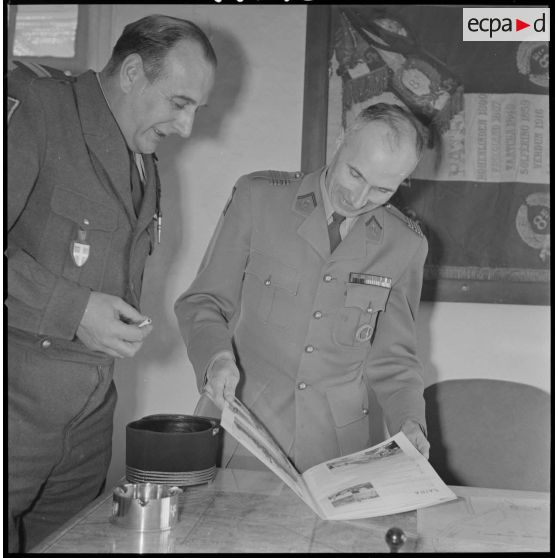 [Camp des chasseurs dans le département de Saïda. Le colonel Maire commandant du 1/8e RIM (à droite) et son adjoint, le commandant Rouquette, regardent une plaquette sur Saïda réalisée par Arthur Smet.]