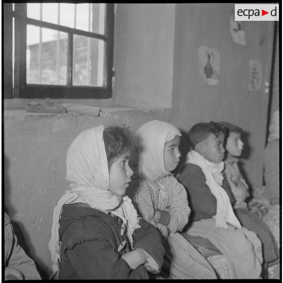 Aménagement de l'eau dans le secteur de Tamesna sous le commandement du capitaine Vinck. Dans une salle de classe, portrait de jeunes enfants assis sur des ballots de foin qui tiennent lieu de bancs d'école. [légende d'origine]