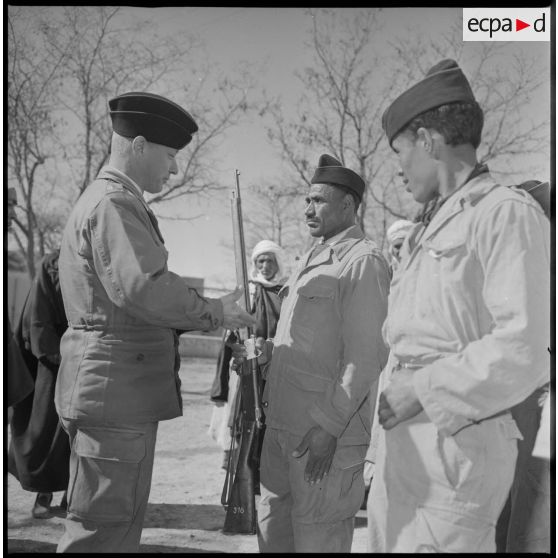 Remise d'un fusil à un membre du nouveau maghzen (ou groupe d'autodéfense) du village de Wagram. [légende d'origine]