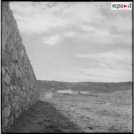 Vue du village surplombant les environs, à l'abri d'un mur récemment édifié. [légende d'origine]