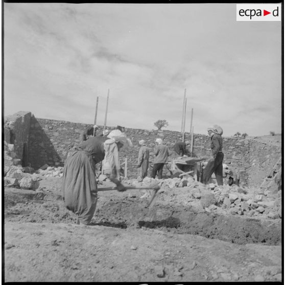 Ouvriers au travail sur un chantier de construction. Travaux de maçonnerie. [légende d'origine]