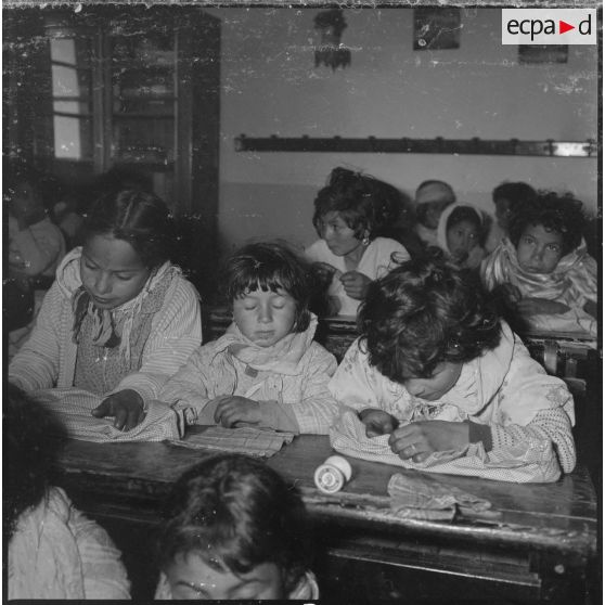 Apprentissage professionnel. Dans une salle de classe, de jeunes élèves apprennent à coudre. [légende d'origine]