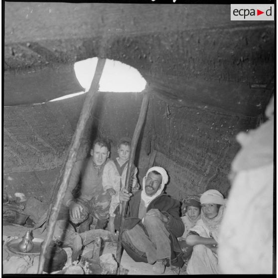 Portrait d'une famille à l'intérieur d'une khaïma. Sur la gauche, Arthur Smet. [légende d'origine]