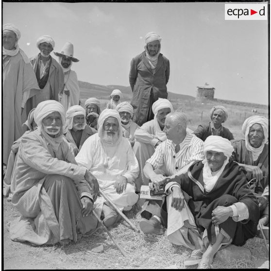 Portrait d'un groupe d'hommes assis sur le sol. [légende d'origine]