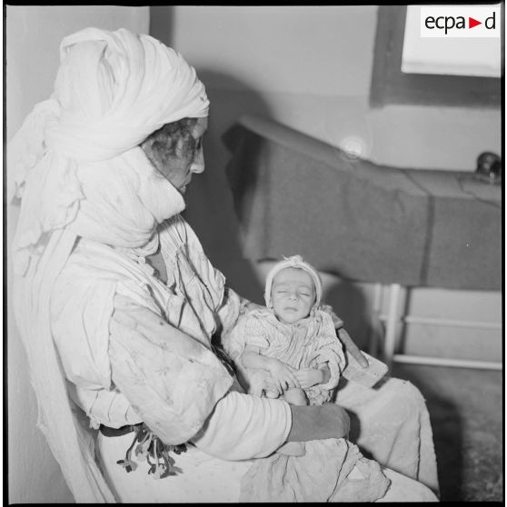 Portrait d'un groupe de femmes et d'enfants assis dans une salle d'attente. [légende d'origine]