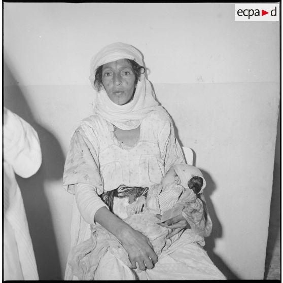 Portrait d'un groupe de femmes et d'enfants assis dans une salle d'attente. [légende d'origine]