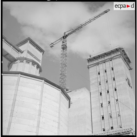 [Vue en contre-plongée d'un silo, d'une grue et d'un bâtiment en construction sur les docks coopératifs de Saïda.]