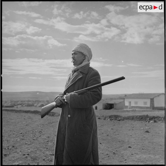 [Portrait d'un villageois appartenant à un groupe d'autodéfense. Debout, un fusil dans les mains, il protège la population algérienne logée dans le centre de regroupement de la ferme Cazorla.]