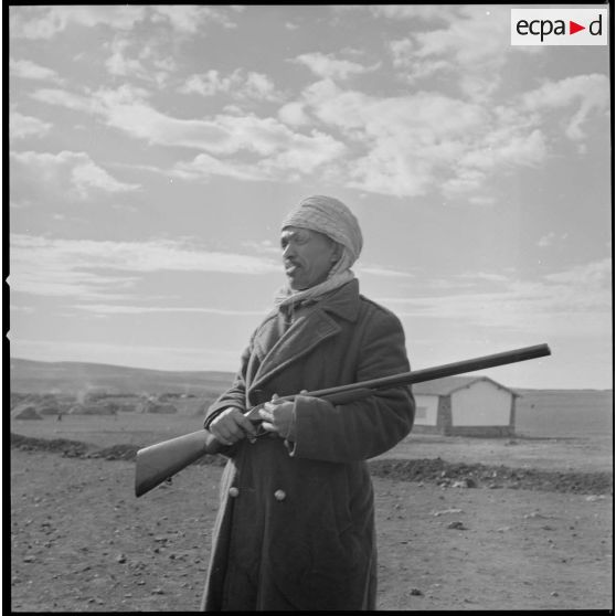 [Portrait d'un villageois appartenant à un groupe d'autodéfense. Debout, un fusil dans les mains, il protège la population algérienne logée dans le centre de regroupement de la ferme Cazorla.]