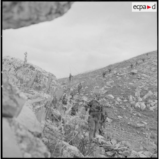 [Soldats du 2/8e RIM en progression dans une zone escarpée au cours d'une opération en Kabylie.]