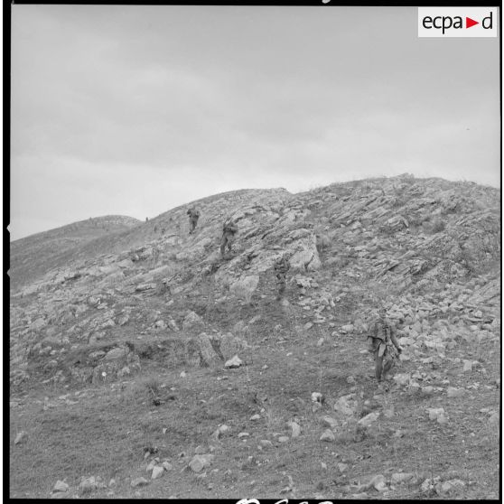 [Colonne de soldats du 2/8e RIM en progression dans une zone escarpée au cours d'une opération en Kabylie.]