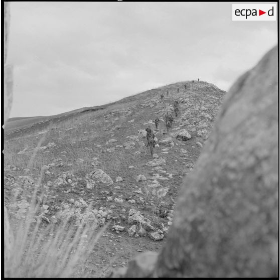 [Colonne de soldats du 2/8e RIM en progression dans une zone escarpée au cours d'une opération en Kabylie.]