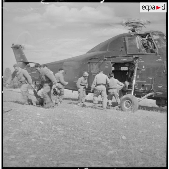 [Opération avec le commando Georges dans le secteur de Fenouane, près de la ferme Garrigues. Soldats débarquant les corps des combattants transportés par hélicoptère du GHAN (groupe d'hélicoptères de l'aéronautique navale).]