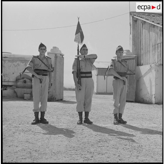 [Soldats d'une compagnie du 2e régiment de zouaves (RZ) présentant les armes au cantonnement de la ferme des Oliviers.]