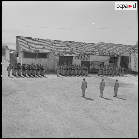 [Compagnie du 2e régiment de zouaves (RZ) présentant les armes à l'occasion d'une cérémonie de passation de commandement au cantonnement de la ferme des Oliviers à Saint-Cloud.]