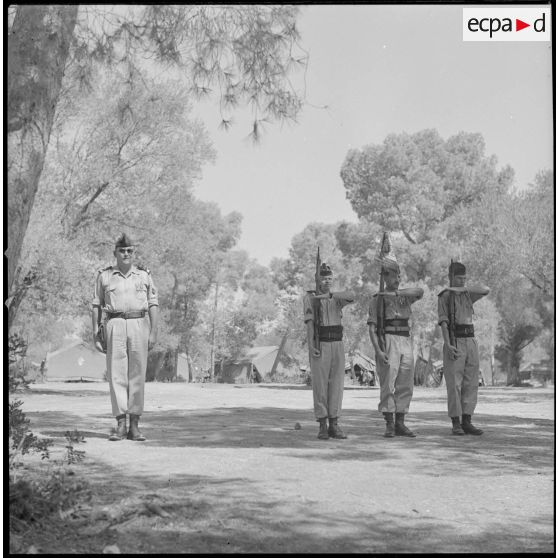 [Soldats de la 5e compagnie du 2e régiment de zouaves (RZ) présentant les armes au campement de la forêt Moulay Ismaïl.]