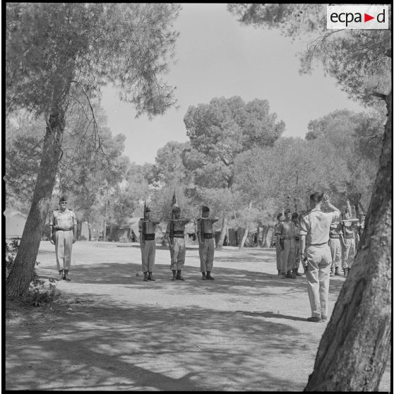 [Soldats de la 5e compagnie du 2e régiment de zouaves (RZ) présentant les armes au campement de la forêt Moulay Ismaïl.]