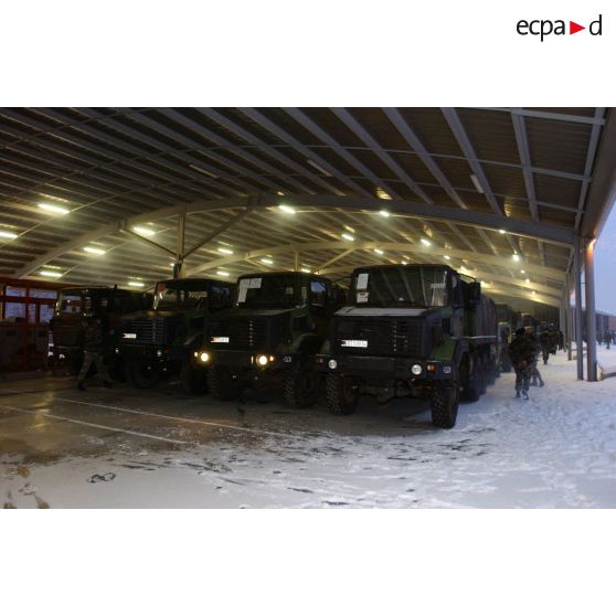 Départ du 7e BCA (bataillon de chasseurs alpins) pour la relève de l'opération Licorne (8e mandat) : vue d'ensemble de camions GBC 180 parqués sous un hangar avant le départ pour l'embarquement par voie ferrée. Les fiches d'identification des véhicules se trouvent sur chaque pare-brise.