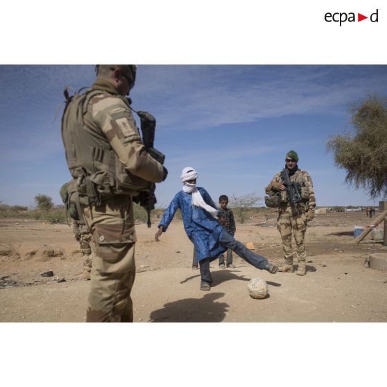 Un groupe de légionnaires joue au football avec des enfants lors d'une ACM à Indelimane.