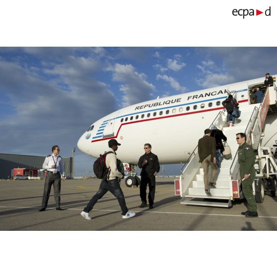 Embarquement de ressortissants évacués par la passerelle de l'Airbus A340 de l'escadron de transport 3/60 Esterel sur l'aéroport de Tripoli (Libye), sous les regards d'un capitaine membre de l'équipage et d'un agent du ministère des Affaires étrangères.