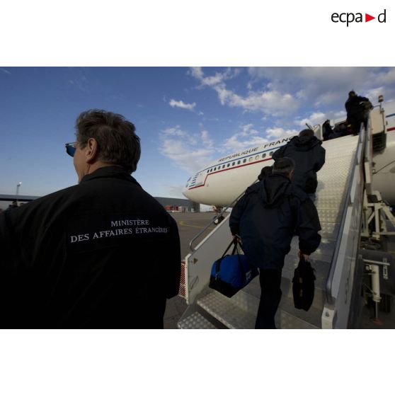 Embarquement de ressortissants évacués par la passerelle de l'Airbus A340 de l'escadron de transport 3/60 Esterel sur l'aéroport de Tripoli (Libye), en présence d'un agent du ministère des Affaires étrangères.