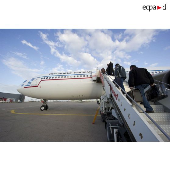 Embarquement de ressortissants évacués par la passerelle de l'Airbus A340 de l'escadron de transport 3/60 Esterel sur l'aéroport de Tripoli (Libye), en présence d'un agent du ministère des Affaires étrangères.