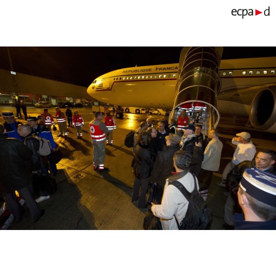 Débarquement de nuit des ressortissants évacués de Tripoli (Libye) en avion Airbus A340 de l'escadron de transport 3/60 Esterel sur l'aéroport de Roissy-en-France, accueillis par des membres de la Croix-Rouge française, des gendarmes et des sapeurs-pompiers de la BSPP (Brigade des sapeurs-pompiers de Paris).