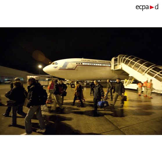 Débarquement de nuit des ressortissants évacués de Tripoli (Libye) en avion Airbus A340 de l'escadron de transport 3/60 Esterel sur l'aéroport de Roissy-en-France, accueillis par des membres de la Croix-Rouge française et des sapeurs-pompiers de la BSPP (Brigade des sapeurs-pompiers de Paris).