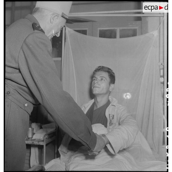 Un légionnaire 2e classe du3/13e DBLE (demi-brigade de Légion étrangère) serre la main du général de Linarès à l'hôpital Lanessan à Hanoï.