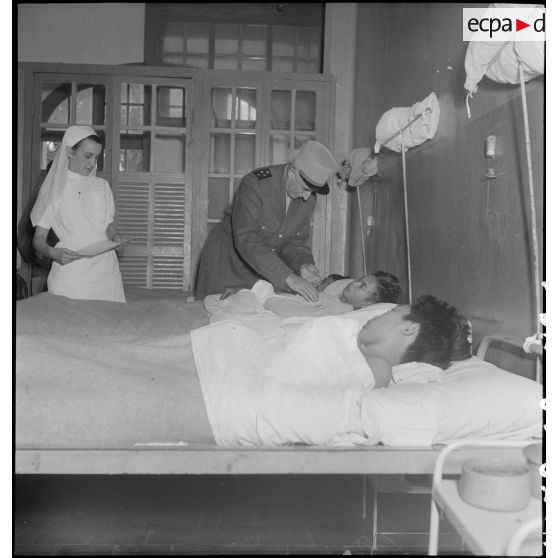 Le général de Linarès au dessus du lit de soldats vietnamiens à l'hôpital Lanessan à Hanoï.