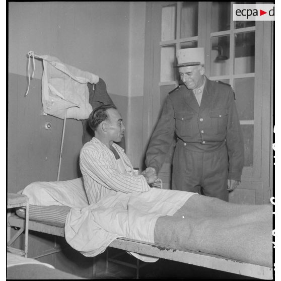 A l'hôpital de Lanessan, un légionnaire 2e classe du I/5e REI (régiment étranger d’infanterie) serre la main du général de Linarès venu remettre des décorations aux soldats blessés.