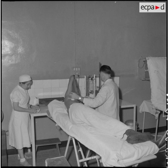 Un médecin soigne un homme à l'hôpital militaire Lanessan.