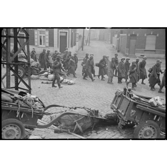 A Thulin (Belgique), place du Calvaire, des chevaux morts encore attelés à leur remorque suscitent la curiosité des prisonniers français qui quittent le village.