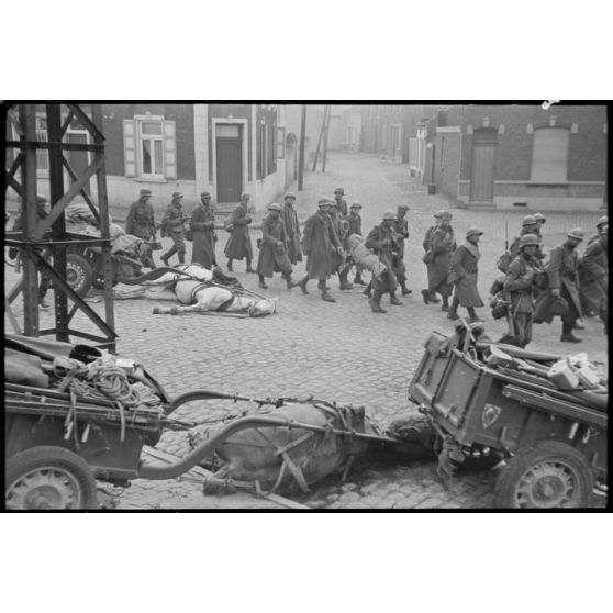 A Thulin (Belgique), place du Calvaire, des chevaux morts encore attelés à leur remorque suscitent la curiosité des prisonniers français qui quittent le village.