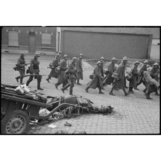 A Thulin (Belgique), place du Calvaire, des chevaux morts encore attelés à leur remorque suscitent la curiosité des prisonniers français qui quittent le village.