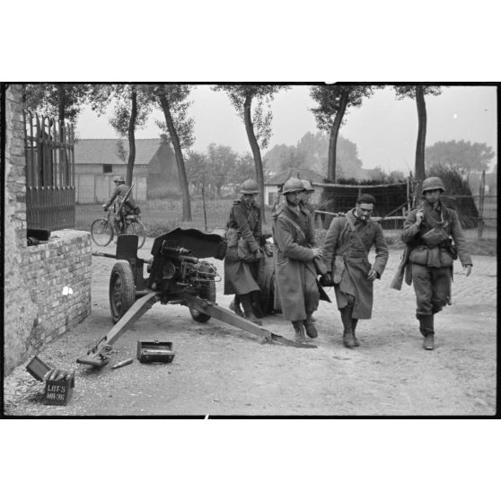 A Thulin, entre les rues du Calvaire et Victor Delporte, des prisonniers français quittent le village, un canon antichar français de 25 mm est encore en position.